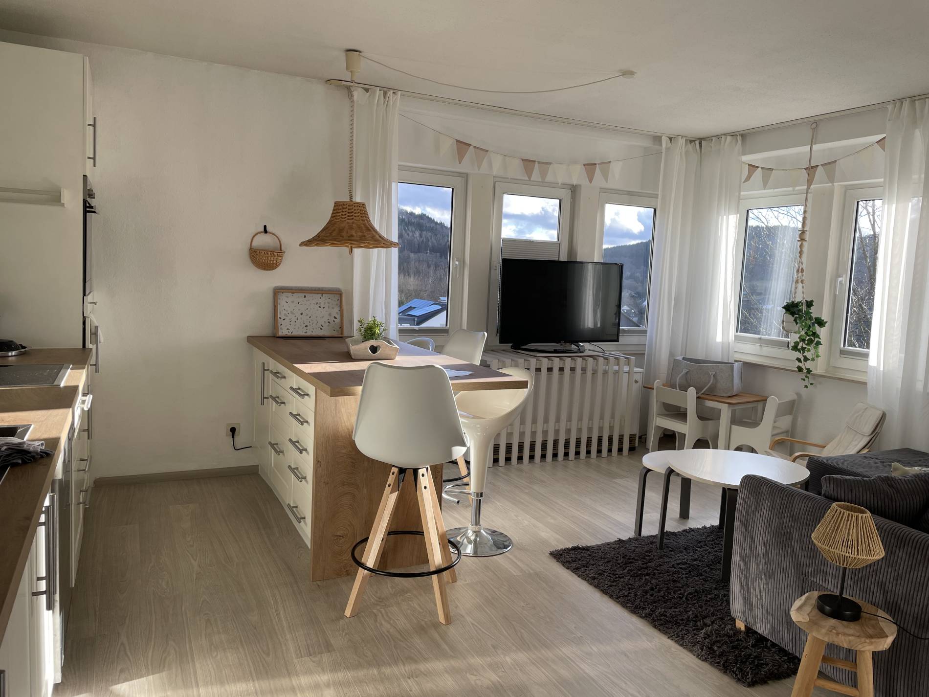 Offener Wohn-Ess-Bereich mit Sofa, Tresen und Bergblick